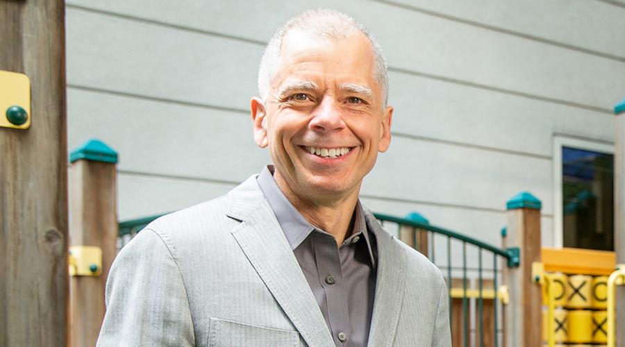 A photo of Joel Nigg, Ph.D. standing in a playground.